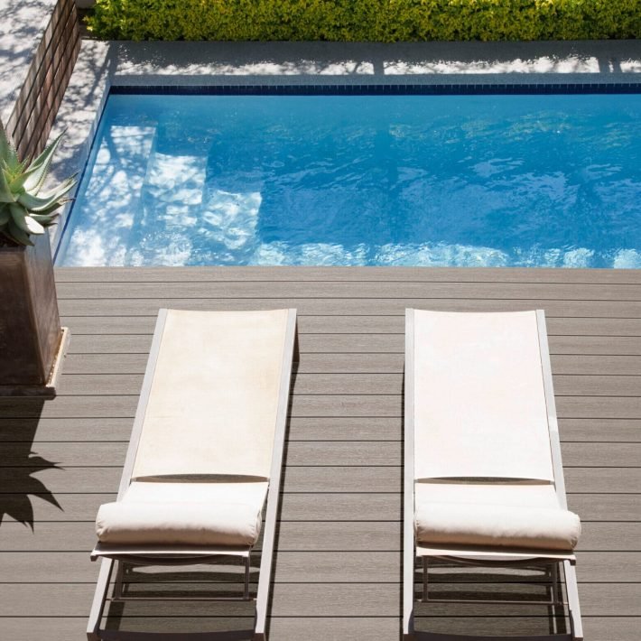 Modern lounge chairs next to swimming pool
